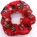 Detail of red mesh scrunchie featuring festive bee and flower prints on fabric - 520 Bee