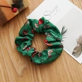 Vue détaillée d'un chouchou vert en satin avec des motifs de Noël festifs - Chaussette de Noël verte