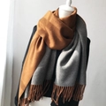 Thick dual-color scarf in orange and grey with long fringes on a white mannequin - Caramel + Grey