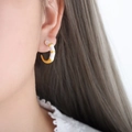 French vintage asymmetric enamel C-shape hoop earrings worn by a model in gold and white - White
