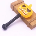 Detail of a yellow Halloween pumpkin magic wand with carved face on a light wooden box - Wink Pumpkin Wand