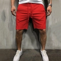 Detail of red sports shorts with drawstring waist and raw edge hem on male model - S / Bottoms / Orange Red