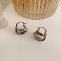 Detalle macro de pendientes de plata con sello 925 en la superficie de metal pulido - Aros Plateados