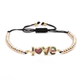 Close-up of woven bracelet featuring colorful zircon LOVE charm and polished metal beads - LOVE Angel