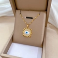 Detail der goldenen Evil-Eye-Halskette mit Kristallen in einer beigen Schmuckschatulle - Teufelsauge Sonne Stil (H203)