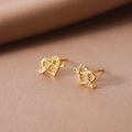 Elegante goldene Herz-Ohrstecker mit Zirkonia-Knoten auf warmem Samthintergrund - Gold