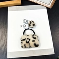 Dettaglio di mini ciondolo a borsa in peluche leopardato con pompon e gancio in metallo - Beige