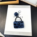 Dettaglio portachiavi a borsa in peluche leopardato blu scuro con pompon e gancio in metallo - Blu