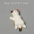 Detail shot of ceramic calico cat chopstick rest showing size 6.5x3x1.5cm on grey background - Style D