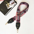Détail d'une bandoulière tissée large avec motifs de cœur et boucles dorées - Charme coloré avec cuir noir