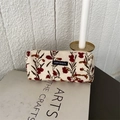 Detail van de crèmekleurige corduroy make-uptas met bloemenborduurwerk op kunstboeken - Beige Windbloem