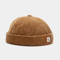 Detailaufnahme einer braunen Cord-Docker-Mütze mit einem Leder-Logo-Patch am Rand - Verstellbar / Khaki