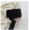 Detailed view of black velvet handbag with vertical quilting and elegant gold chain strap - Black