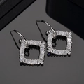Elegante geometrische zilveren vierkante oorbellen met zirkonia op reflecterend oppervlak - Zilver (Witgoud Verguld)