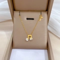 Collar minimalista de nota musical dorada con piedras sobre tela de seda beige - Acero de titanio / Dorado