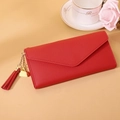 Close-up of red faux leather wallet with metallic heart pendant and tassel detail - Long Style / Red