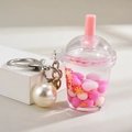 Vista macro portachiavi bubble tea con perle rosa, fiocchi dorati e un grande ciondolo perla - Catena con Chiusura a Moschettone + Mini Tazza di Bubble Tea + Perla / Rosa Rossa