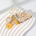 Detailed macro shot of DOG mama engraved wood tag with golden retriever enamel charm - Yellow Tassel + Golden Retriever