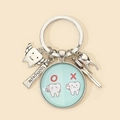 Dettaglio del portachiavi da dentista con ciondoli a forma di dente e dentifricio - Stile 4 (Contrasto Salute Dentale)