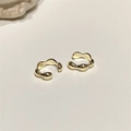 Dettaglio di ear cuff dorati a forma di onda minimalista con moderne curve irregolari - Coppia d'oro
