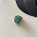 Top view of textured gold ring featuring a prominent turquoise stone on white background - US 7 / Turquoise