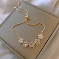 Detailed macro view of adjustable gold star flower bracelet with pavé crystal zirconias - 13# Zirconia Flower Slider