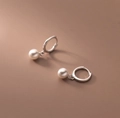 Eleganti orecchini a cerchio argentati con perle bianche pendenti su base marrone calda - Argento