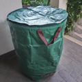 Detailed close-up of a large green garden waste bag with zipper lid and striped handles - 120L / With Lid
