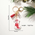 Portachiavi a calza di Natale con nappa e sfera di paillettes su sfondo festivo - Calza di Natale Stile 1