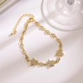 Detailed close-up of gold star charms and zircon inlay on a Cuban chain bracelet - Five-pointed Star