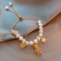 Baroque pearl bracelet with gold teddy bear and star charms on soft blue silk fabric - Freshwater Pearl Bear Style