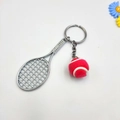 Detailaufnahme von silbernem Tennisschläger und rotem Filzball als Schlüsselanhänger - Rosarot