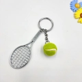 Detailansicht eines Tennis-Schlüsselanhängers mit silbernem Schläger und gelbem Plüschball - Fluoreszierendes Grün