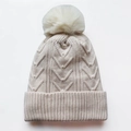 Beigefarbene Damen Strickmütze mit Kunstpelz-Bommel und Perlenverzierung auf weißem Grund - Verstellbar / Beige