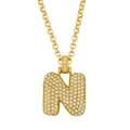 Macro shot of bubble letter N pendant necklace in 18K gold with pave cubic zirconia stones - Letter N