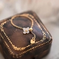 Adjustable gold chain ring featuring white shell clover and heart charm on leather box - Adjustable Chain / Faux White Shell Gold