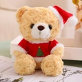 Close-up of a light brown teddy bear in a red Christmas sweater and hat on a desk - Red T-shirt Style (Light Brown Bear)