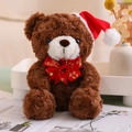 Close-up of brown teddy bear with Christmas hat and Merry Christmas bow on a white tray - Red Bow Tie Style (Dark Brown Bear)