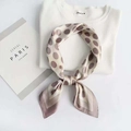 Elegant polka dot satin silk scarf in beige and brown tied in a stylish knot - Coffee