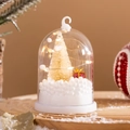 Close-up of a warm LED Christmas tree light with mini gift box and faux snow inside - C (warm Light)