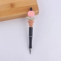 Close-up of pink daisy flower pot silicone topper on a sleek black ballpoint writing pen - Pink
