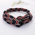 Crisscross knotted headband featuring black fabric with red and white geometric patterns - Large Black Plaid