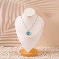 Elegant solid wood neck display stand featuring a blue heart pendant necklace with palm leaf shadow - Large / Beige