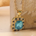 Collana in titanio dorato con pendente in zircone azzurro quadrato e cristalli - Zirconia Blu