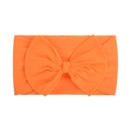 Detail of soft nylon orange baby headband featuring a large knitted bow on white background - Orange (011)