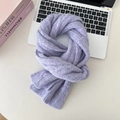 Close-up of soft purple cable knit wool scarf on a white desk with professional styling - Taro Purple