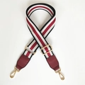 Detail of adjustable red striped woven bag strap with red leather ends and gold metal buckles - Black + Burgundy Leather