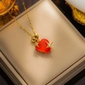Dettaglio macro di un ciondolo a cuore in gemma rossa con accenti di stelle dorate - Rosso(8808)