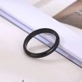 Primer plano de un anillo negro pulido minimalista sobre un elegante libro blanco - US 5 / Negro