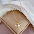 Detail of a gold heart pendant with micro-pave crystals on a soft silk background - Gold